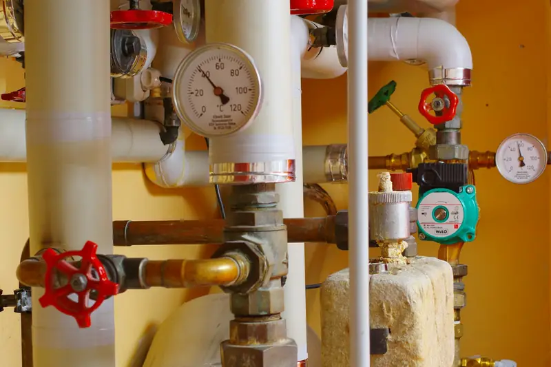 Copper and insulated heating pipes with valves, a pump and a pressure gauge