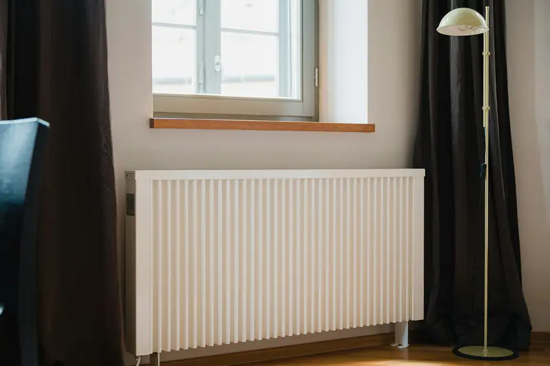 White panel radiator fitted under a window in a living room