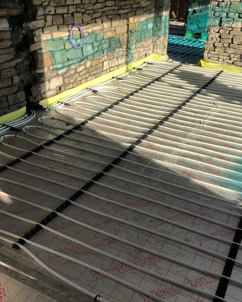 Underfloor heating pipes laid in loops over insulation boards before screeding